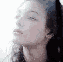 a close up of a woman 's face with a blurred background .