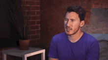 a man in a purple shirt is looking up with the word how above him