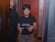a woman wearing a bad bitch good karma t-shirt