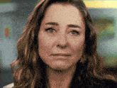 a close up of a woman 's face with a sad expression