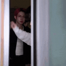 a man with red hair is standing in a doorway with another man .