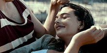 a man and a woman are laying on a bed and the woman is smiling
