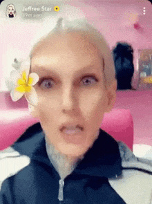 a woman with a flower in her hair is making a face .