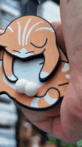 a close up of a person holding a cat key chain