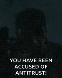 a man is holding a gun in his hand and says `` you have been accused of antitrust ! ''