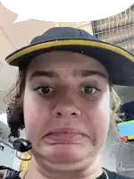 a woman wearing a hat and a headset makes a face