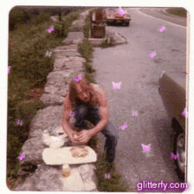 a man is kneeling down on the side of the road with a plate of food in front of him