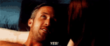 a man is laying on a bed with a woman and smiling while saying yes .