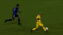 a soccer player wearing a yellow jersey with the number 2 on it kicks the ball