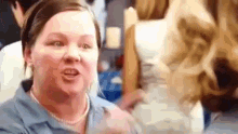 a woman in a blue shirt is talking to another woman .