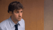 a man in a blue shirt and tie is looking at something .