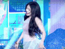 a woman with long hair is dancing on a stage in a room .
