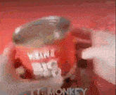 a person is holding a red mug that says monkey