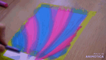 a person is painting on a piece of paper which says made in animatica