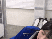a woman laying in a blue blanket with korean writing on the bottom right