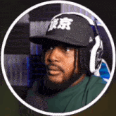 a man with a beard wearing headphones and a baseball cap .