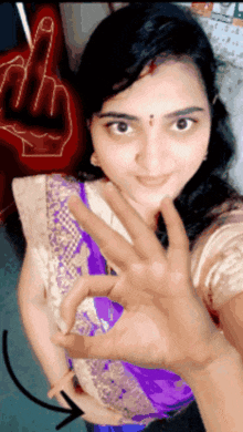 a woman taking a selfie with her hand in front of a middle finger sign