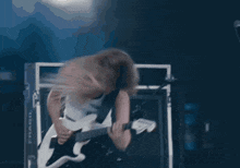 a woman playing a guitar with a tank top that says ' dunlop ' on it