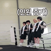 a group of young men are standing in a boxing ring with korean writing on the wall