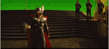 a man in a superhero costume stands in front of a green background