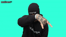 a man wearing a black beanie and a black sweater with the word multivers on it