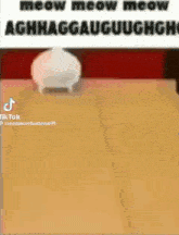 a cartoon cat is walking on a wooden floor next to a vase .