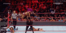 a woman is being thrown into a wrestling ring while a referee watches .