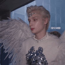 a close up of a person wearing angel wings and a tiara