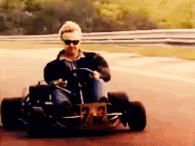 a man is driving a go kart with the number 23 on the back