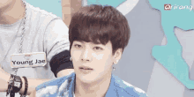 a young man wearing a name tag with the name young jae on it