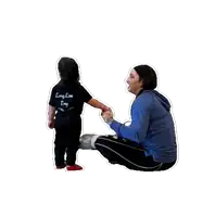 a little girl wearing a long live tiny shirt holds the hand of a woman