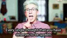a man wearing glasses and a pink shirt says every single thought that you have deserves to be spoken .