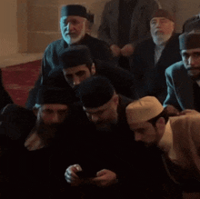a group of men wearing hats are gathered in a dark room