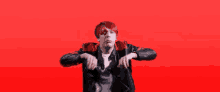 a man with red hair is wearing a black jacket