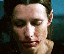 a close up of a woman 's face with blood on her mouth