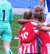 a group of soccer players are hugging and one of them has the number 10 on her jersey
