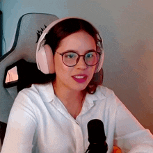 a woman wearing glasses and headphones sits in a chair with a corsair logo on the back