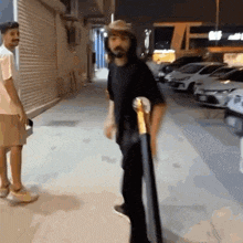 a man in a cowboy hat is holding a skateboard