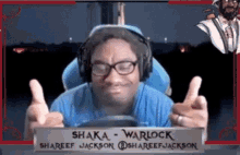 a man wearing headphones and glasses is giving a thumbs up sign