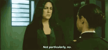 two women are talking to each other in a hallway and one of them is saying not particularly no .