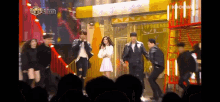a group of people are performing on stage in front of a sign that says ' i give you '