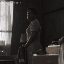 a woman is standing in a dark room with #highcastle written on the bottom right