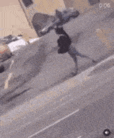 a person is walking down a street in front of a parking lot with cars .