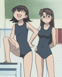 two girls in swimsuits are standing next to each other and one is sitting on a chair