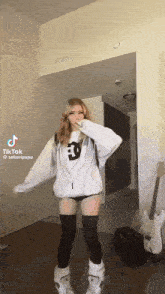 a girl is dancing in a room with a guitar .