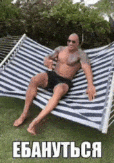 a man without a shirt is sitting in a hammock with a drink in his hand
