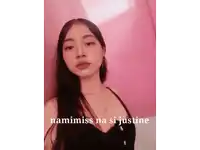 a woman in a black top is standing in front of a pink wall with the words namimiss na si justine on the bottom