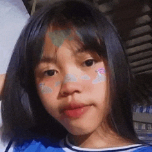 a close up of a young girl with a blue shirt on .