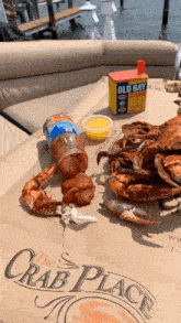 crabs are sitting on a table with a box of old bay seasoning in the background