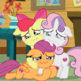 a group of ponies are laying on the floor and one of them has a diamond on her tail